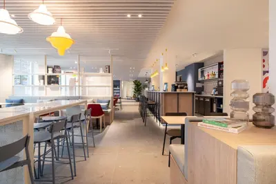 a restaurant with tables and chairs and a bar at Holiday Inn Express & Suites Ghent by IHG in Ghent