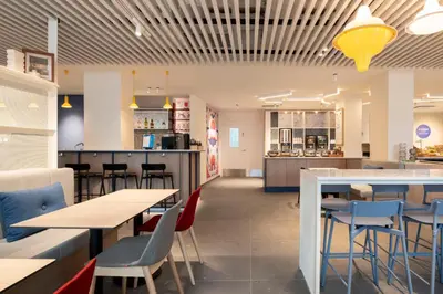 a restaurant with tables and chairs and a bar at Holiday Inn Express & Suites Ghent by IHG in Ghent
