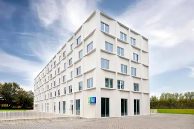 a white building with windows on the side of it at Holiday Inn Express & Suites Ghent by IHG in Ghent