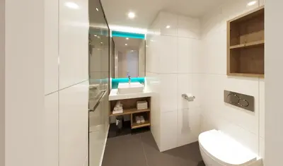 a white bathroom with a toilet and a sink at Holiday Inn Express & Suites Ghent by IHG in Ghent