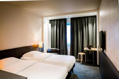 a hotel room with two beds and a television at Hotel Van Belle in Brussels