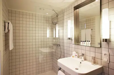 a white bathroom with a sink and a mirror at Hotel Van Belle in Brussels
