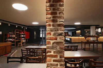 a room with tables and chairs and a brick wall at Hotel Van Belle in Brussels