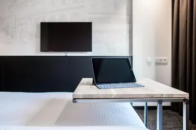 a laptop computer sitting on a table next to a bed at Hotel Van Belle in Brussels