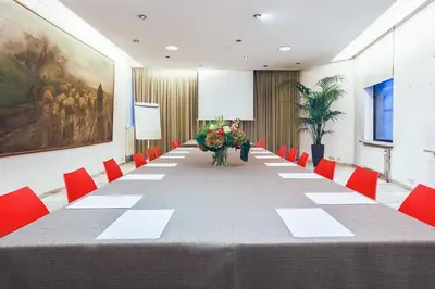 a large conference room with a long table and red chairs at Hotel Van Belle in Brussels