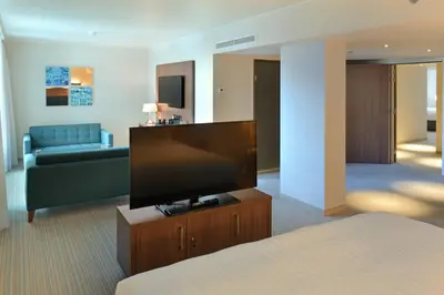 a living room with a flat screen tv and a couch at Courtyard by Marriott Brussels EU in Brussels