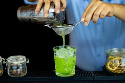 a person is pouring lime juice into a glass at Courtyard by Marriott Brussels EU in Brussels