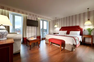 a hotel room with a large bed and a chair at Eurostars Montgomery in Brussels