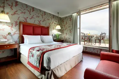 a bedroom with a bed and a window and a chair at Eurostars Montgomery in Brussels