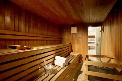 a wooden sauna with a white chair in it at Eurostars Montgomery in Brussels