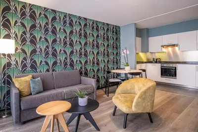 a living room with a couch and a kitchen at Thon Hotel Residence Parnasse Aparthotel in Brussels