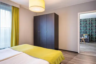a bedroom with a bed with a yellow blanket at Thon Hotel Residence Parnasse Aparthotel in Brussels