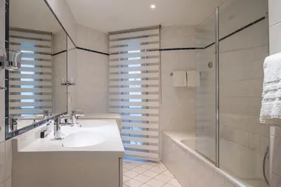 a bathroom with a sink and a shower at Thon Hotel Residence Parnasse Aparthotel in Brussels