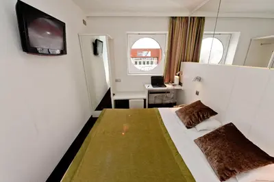 a bedroom with a bed and a desk with a laptop at Hotel Expo in Brussels