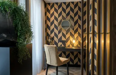 a room with a chair and a mirror on a wall at Leonardo Hotel Antwerp The Plaza in Antwerp