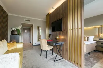 a hotel room with a bed and a desk with a television at Leonardo Hotel Antwerp The Plaza in Antwerp