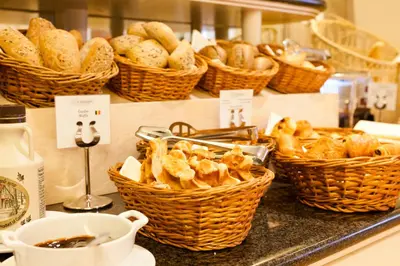 a bunch of baskets of bread on a counter at Hotel Le Châtelain in Brussels