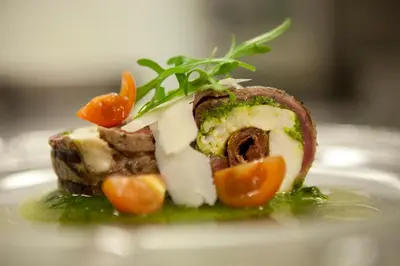 a piece of food on a plate with vegetables on it at Hotel Le Châtelain in Brussels