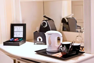 a counter with a coffee maker and cups on it at Hotel Le Châtelain in Brussels