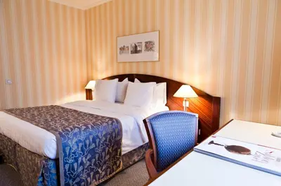a hotel room with a bed and a table at Hotel Le Châtelain in Brussels