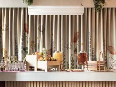 a table with fruit on it in front of a curtain at Hotel Novotel Brussels Off Grand Place in Brussels