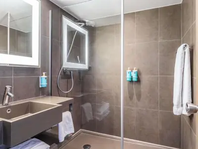 a bathroom with a sink and a shower at Hotel Novotel Brussels Off Grand Place in Brussels