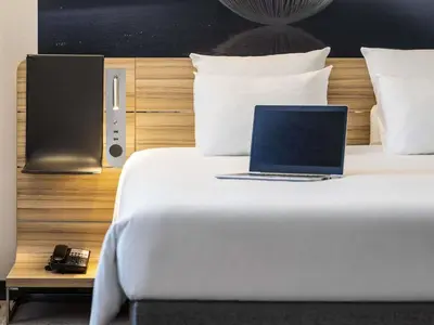 a laptop computer sitting on top of a bed at Hotel Novotel Brussels Off Grand Place in Brussels