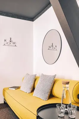 a living room with a yellow couch and a table at Zoom Hotel in Brussels