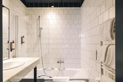 a white bathroom with a tub and a sink at Zoom Hotel in Brussels