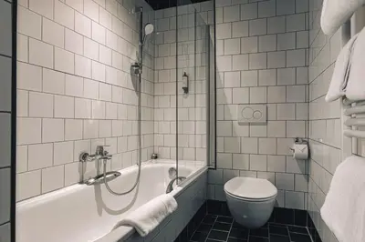 a bathroom with a tub and a toilet and a sink at Zoom Hotel in Brussels