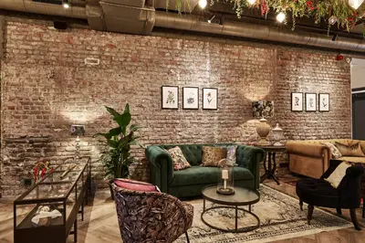 a living room with a green couch and a brick wall at Urban Yard Hotel in Brussels