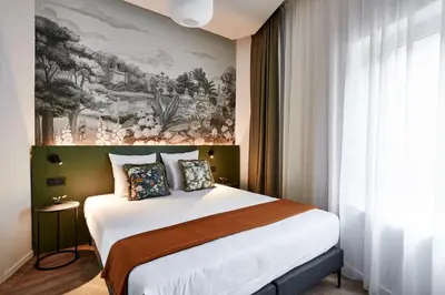 a hotel room with a bed and a painting on the wall at Urban Yard Hotel in Brussels