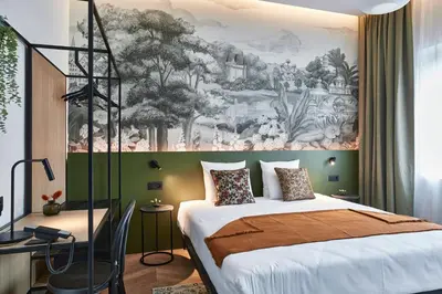 a bedroom with a bed and a painting on the wall at Urban Yard Hotel in Brussels