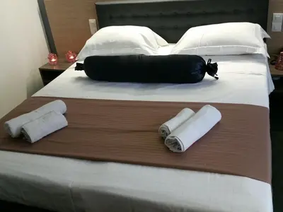 a large bed with two rolled towels on it at Hotel Prince de Liege in Brussels