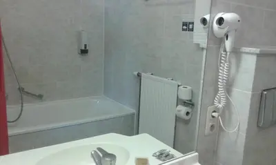 a bathroom with a sink and a shower with a phone at Hotel Prince de Liege in Brussels