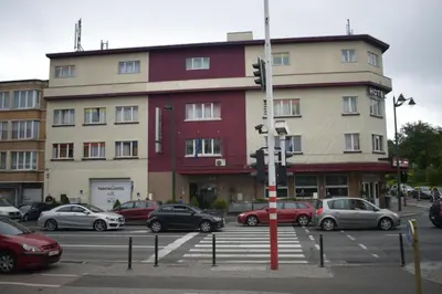 a large building with cars parked in a parking lot at Hotel Prince de Liege in Brussels