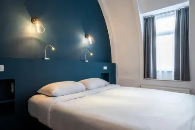 a bedroom with a bed with two pillows and a window at Beverly Hills Hotel in Brussels