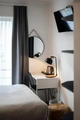 a bedroom with a bed and a desk with a mirror at Beverly Hills Hotel in Brussels