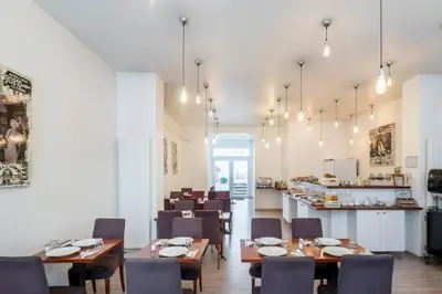 a dining room with wooden tables and chairs at Beverly Hills Hotel in Brussels