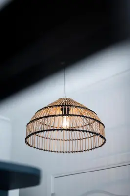 a rattan pendant light hanging from a ceiling at Beverly Hills Hotel in Brussels