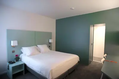 a bedroom with a large white bed and a window at Hotel Du Congres in Brussels