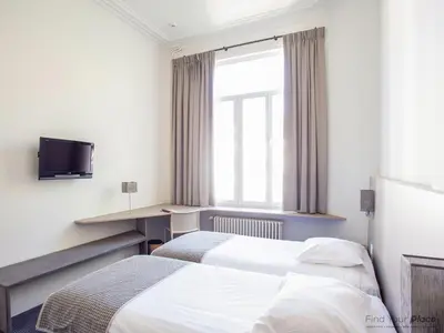 a hotel room with two beds and a television at Hotel Du Congres in Brussels