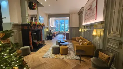 a living room with a christmas tree and a fireplace at Hotel Du Congres in Brussels