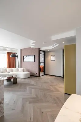 a living room with a white couch and wooden floors at Hyllit Hotel in Antwerp