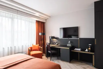a hotel room with a bed and a desk and a tv at Hyllit Hotel in Antwerp