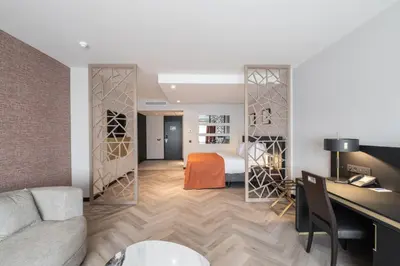 a living room with a bed and a desk in a room at Hyllit Hotel in Antwerp