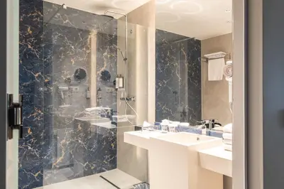 a bathroom with a glass shower and a sink at Hyllit Hotel in Antwerp