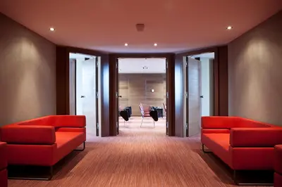 a waiting room with red couches and a meeting room at Hyllit Hotel in Antwerp