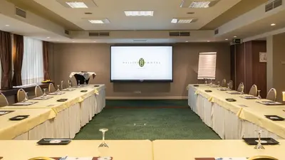 a conference room with long tables and a projection screen at Hyllit Hotel in Antwerp