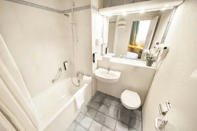 a white bathroom with a sink and a toilet at DC Sleep & Go Brussels West in Brussels